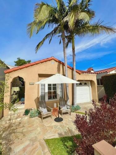 ein Haus mit zwei Stühlen und einem Regenschirm in der Unterkunft Three Bedroom Home in Long Beach in Belmont Shore
