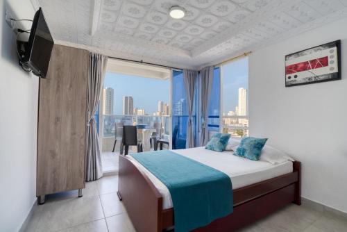 a bedroom with a bed and a view of a city at Maralago el Conquistador Apartamentos Cartagena in Cartagena de Indias