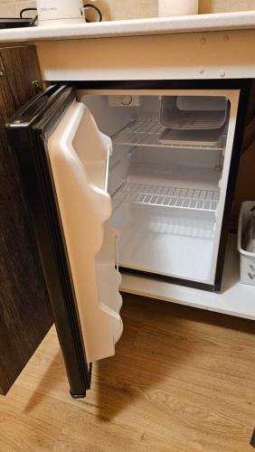 an open refrigerator with its door open in a kitchen at MINiLUx in Ventspils