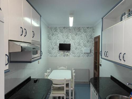 a small kitchen with a table and a microwave at Apartamento Tellería con parking gratis in Barakaldo