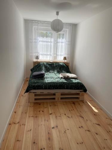 una cama en una habitación con suelo de madera en Święty Spokój, en Gdansk