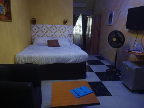 Un dormitorio con una cama, una mesa y un sofá. en Grandsheffield 8 hotel, en Mama