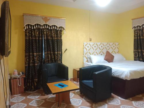 una habitación de hotel con una cama y una silla en Grandsheffield 8 hotel, en Mama