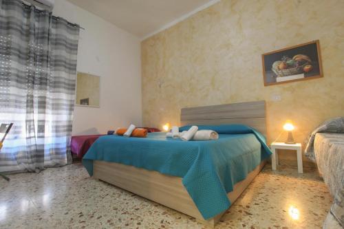 a bedroom with a bed with a blue blanket at low cost airport room catania bagno privato in camera 800 mt aeroporto in CTA