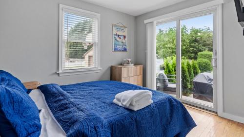 a bedroom with a blue bed and a window at Newport Beach House with Huge Yard in Middletown
