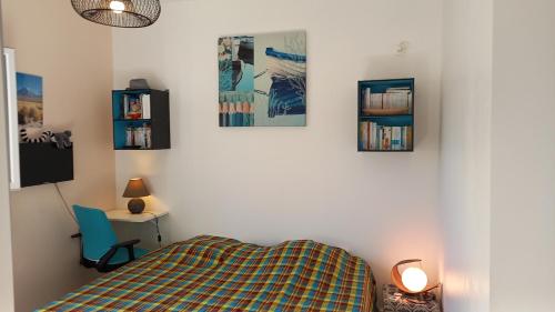 a bedroom with a bed and three pictures on the wall at Maison indépendante avec piscine privée in Vieux-Habitants