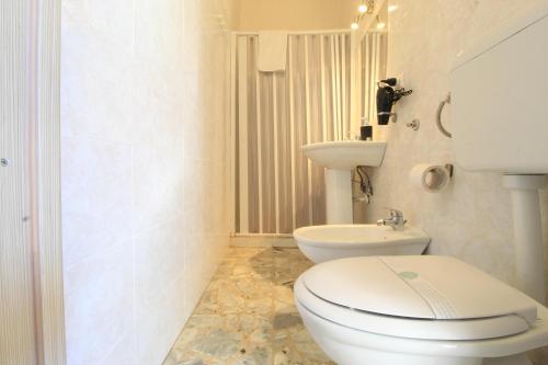 a white bathroom with a toilet and a sink at low cost airport room catania bagno privato in camera 800 mt aeroporto in CTA