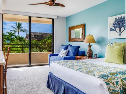 a bedroom with a bed and a view of the ocean at Polo Beach Club 301 in Wailea