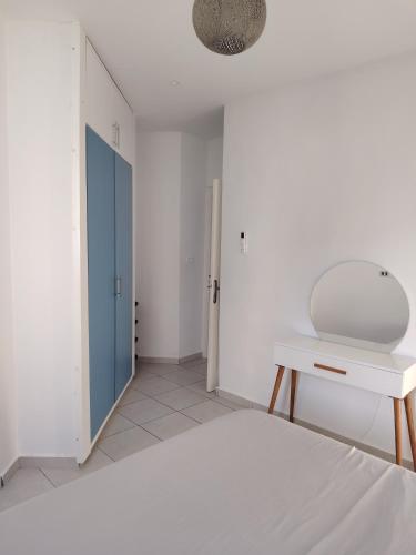 ein weißes Schlafzimmer mit Bett und Schreibtisch in der Unterkunft Dorra house in Tunis