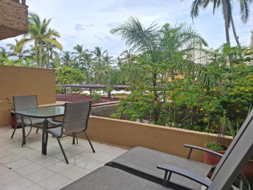 a balcony with a table and chairs and palm trees at studio Opa in Puerto Vallarta