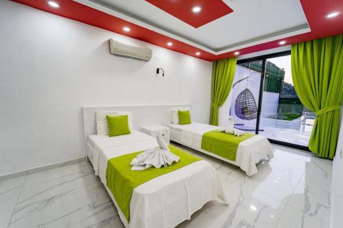 zwei Betten in einem Zimmer mit grünen Vorhängen in der Unterkunft Villa Alya 1-2-3 in Kalkan