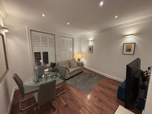 a living room with a glass table and a couch at Discover London Central 2 Bedroom in Kensington in London
