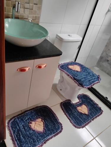 Un baño con lavabo y dos alfombras en el suelo. en Casa Vale dos Peões Lumiar 2, en Nova Friburgo