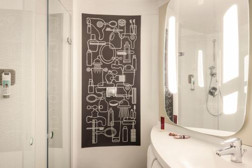 a bathroom with a black and white pattern on the wall at ibis Cambridge Central Station in Cambridge