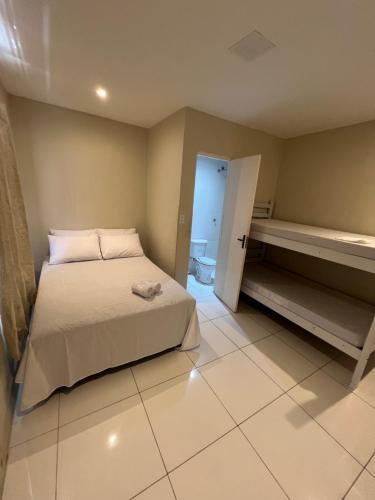 a small bedroom with a bed and a bathroom at Pousada Aconxego in Fortaleza