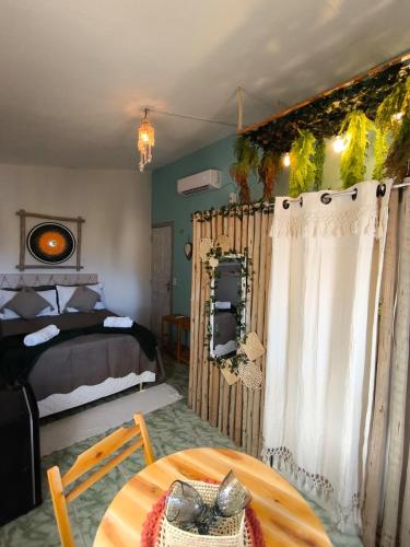 a bedroom with a bed and a table in a room at Hospedaria Mandacaru in Canoa Quebrada