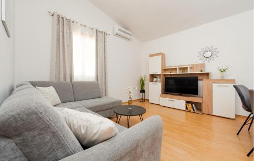 a living room with a couch and a tv at One-Bedroom Apartment In Podgradina in Islam Grčki