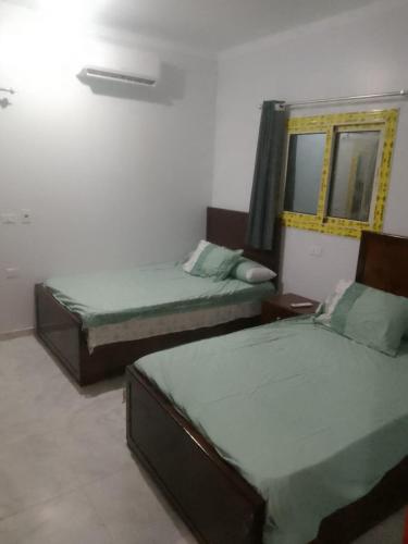 a bedroom with two beds and a mirror at Melia house in Marsa Alam City