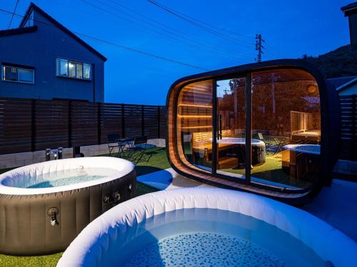 a hot tub on a patio with a view of a backyard at Villa & Sauna - NAGIOTO - - Vacation STAY 20253 in Fujinowaki