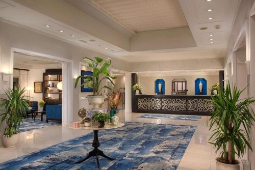 a lobby with potted plants and a table at NH Catania Parco degli Aragonesi in Catania