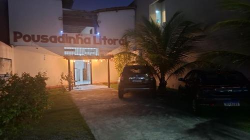 a car parked in front of a building at night at Pousadinha Litoral in Mucuri