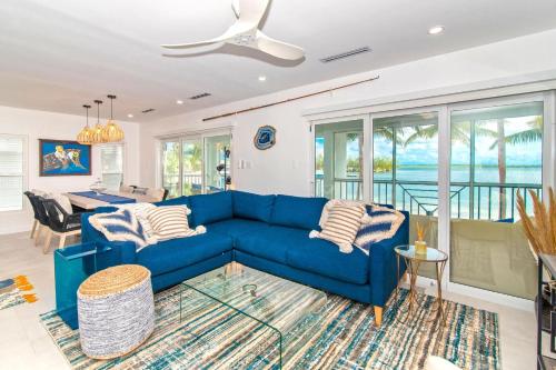 un salon avec un canapé bleu et une table dans l'établissement Kailua - Modern Waterfront Condo with Shared Pool and Hot Tub, Short Walk to the Kaibo, à Driftwood Village