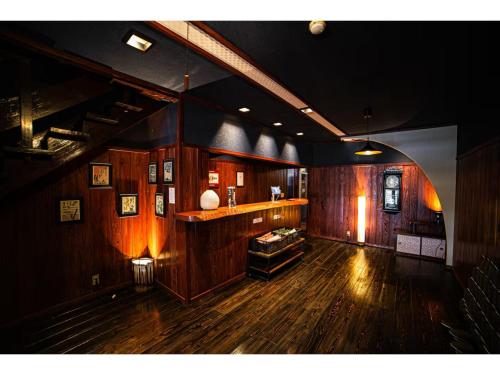 KoguribayashiにあるPARK TSUETATE - Vacation STAY 47999vのウッドフロアの広い客室で、バーが備わります。