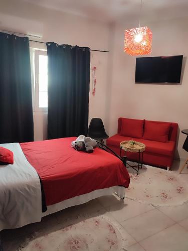 a bedroom with a red bed and a red couch at Ονειροπαγίδα in Veria