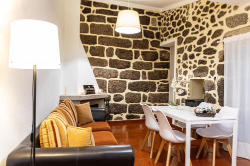 a living room with a stone wall at Recanto da Neta in Seia