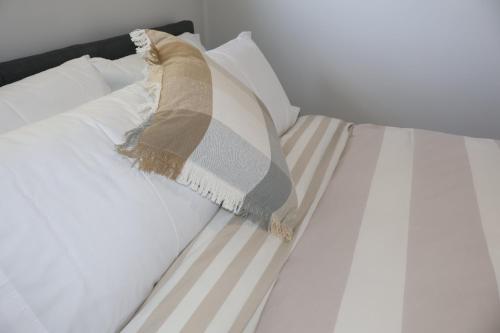 a white bed with a pillow on it at Proline Serviced Apartments