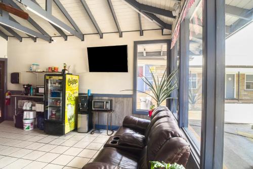 a living room with a couch and a flat screen tv at Colony Inn By OYO Columbus US-280 in Columbus