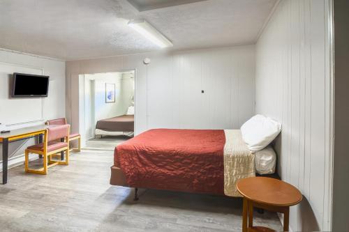 a bedroom with a bed and a desk in a room at Colony Inn By OYO Columbus US-280 in Columbus