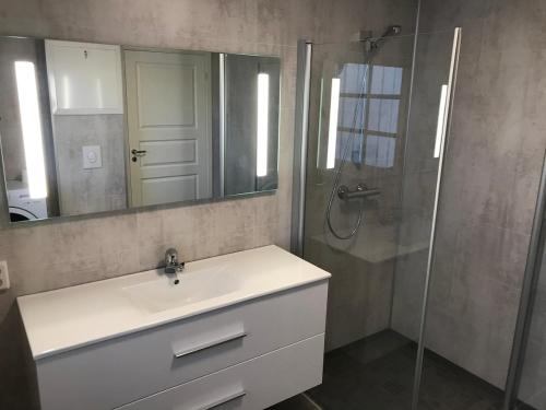een badkamer met wastafel en douche met spiegel bij Strand farm, sea view and boat rental in Averoy