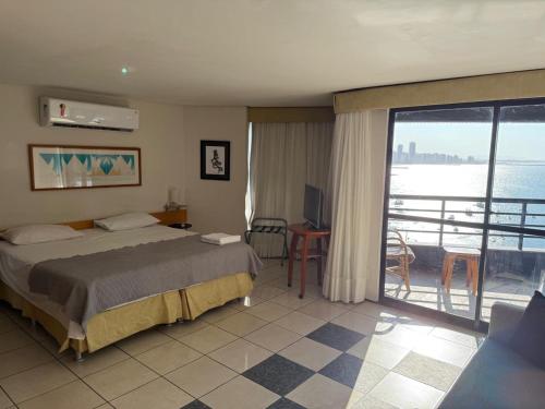 una camera d'albergo con un letto e un balcone di Flat - Iate Plaza Hotel a Fortaleza