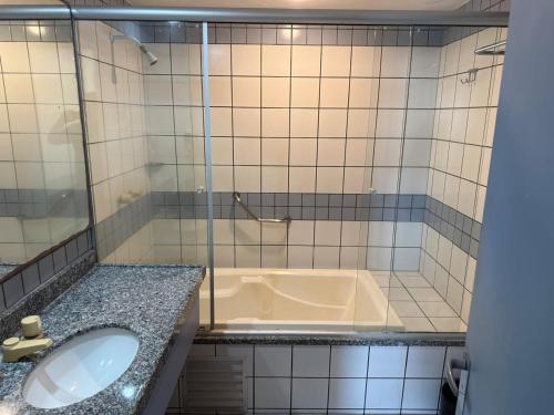 un bagno con vasca e lavandino di Flat - Iate Plaza Hotel a Fortaleza
