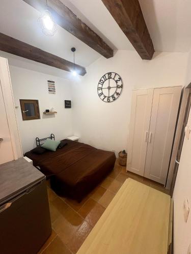 a bedroom with a bed and a clock on the wall at Le Cabanon des Collines in Signes