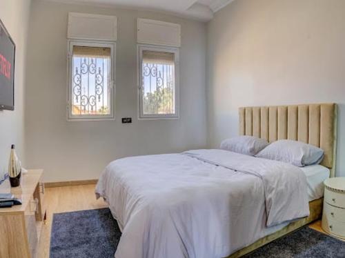 a bedroom with a large bed and two windows at jaws wave agadir 2 in Agadir