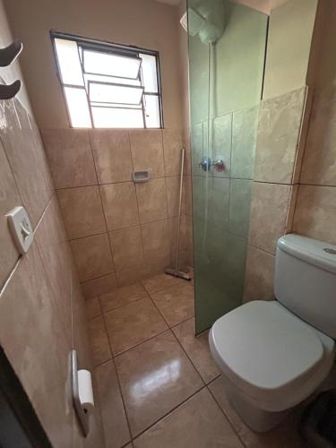 a bathroom with a toilet and a glass shower at Hotel Izaura Centro Comercial Juruaia in Juruaia