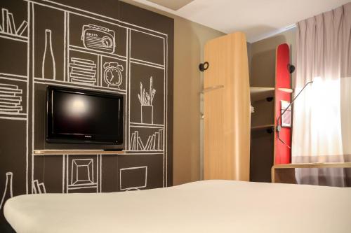 a bedroom with a black wall with drawings on it at ibis Cambridge Central Station in Cambridge