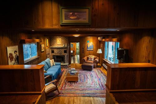 a living room with a blue couch and a fireplace at Twin Oaks Near Lake Wallenpaupack Historic Home in Hawley