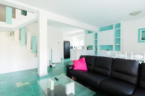 a living room with a black couch and a table at VILLA LILLA Beachfront - Sea View with Parking and Private Garden in Anzio