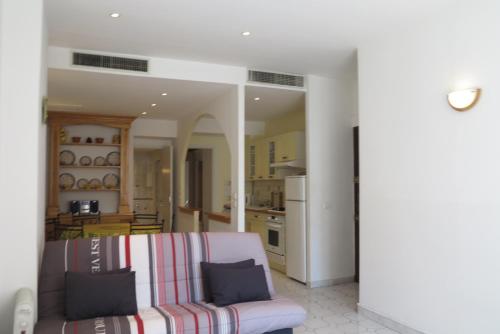 un salon avec un canapé et une cuisine dans l'établissement Viva Riviera - 5 Rue Commandant André, à Cannes