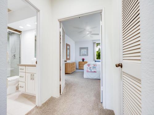 a bathroom with white walls and a door leading to a bedroom at Wailea Grand Champions 177 in Wailea