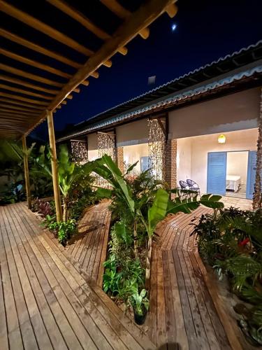 a house with a wooden deck with plants on it at Pousada Buji in Maracajaú