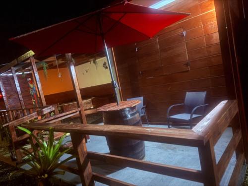 a table with a red umbrella and a chair at Campo Adentro Cabin 2 Private Jacuzzi in Aguada