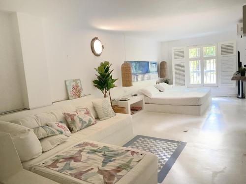 a white living room with a couch and a table at Apartment in the Historical Center of Cartagena in Cartagena de Indias