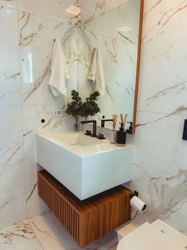 a bathroom with a white sink and a mirror at Loft do Edu in Ortigueira