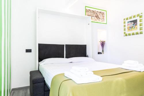 a white bedroom with a bed with a yellow blanket at La Casetta Verde con Vista Mare - Nel cuore del Parasio e delle Logge di Santa Chiara in Imperia