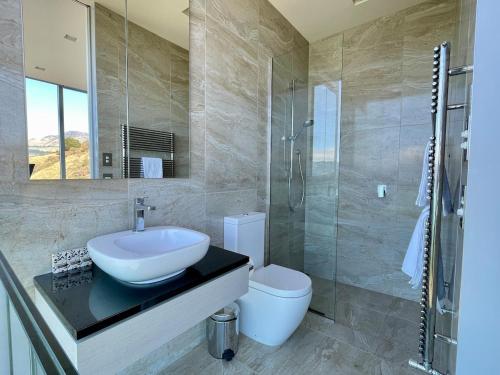 een badkamer met een wastafel, een toilet en een douche bij Executive Home with Stunning Harbour views in Diamond Harbour