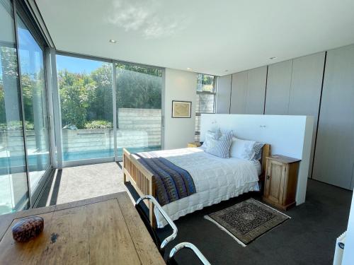 een slaapkamer met een bed en een groot raam bij Executive Home with Stunning Harbour views in Diamond Harbour